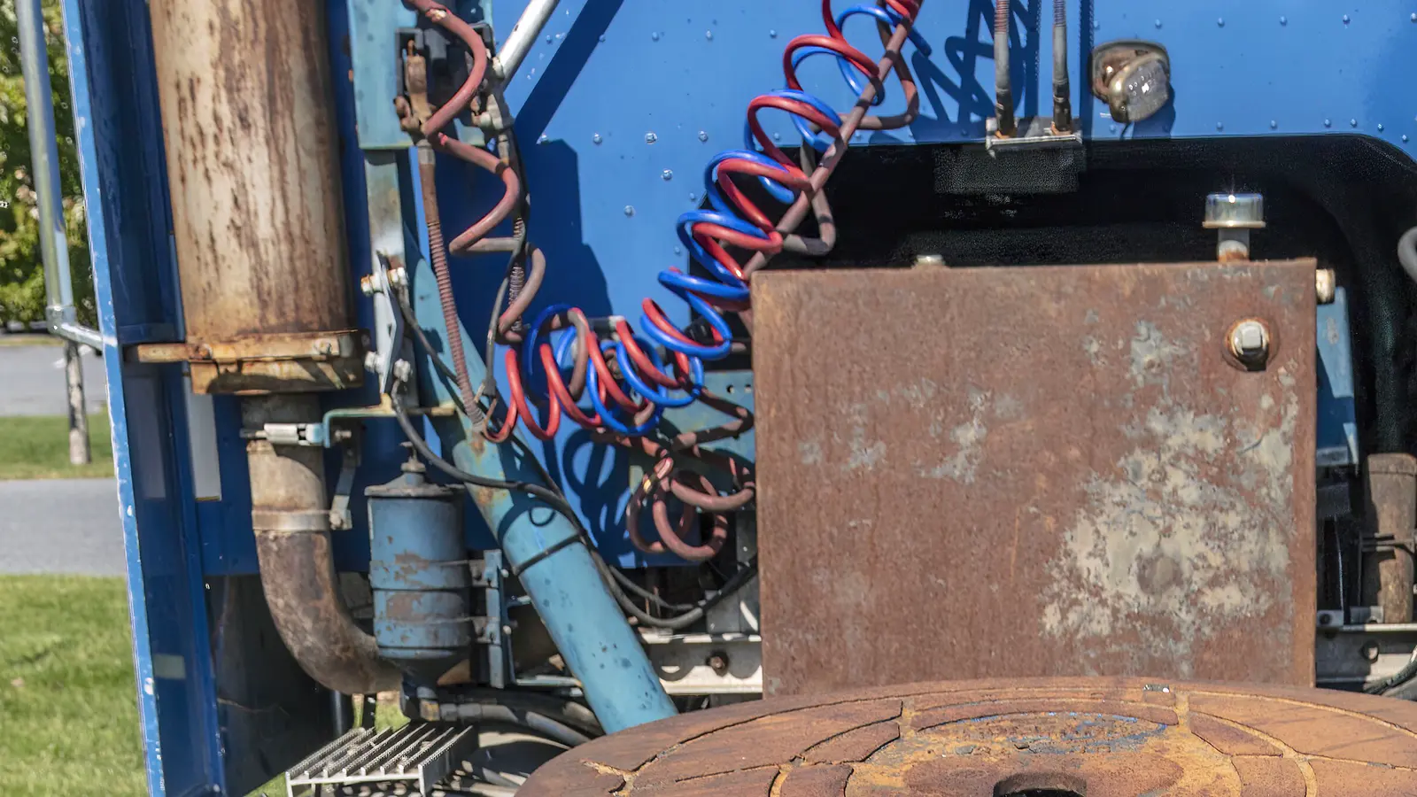 Coiled red and blue air lines beside the fifth wheel on the back of a tractor.